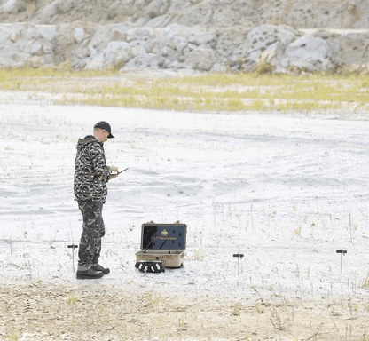 A man using the OKM GeoSeeker metal detector on a beach for scanning