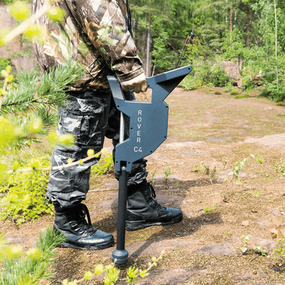 A man using the OKM Rover C4 ground scanner in a forest